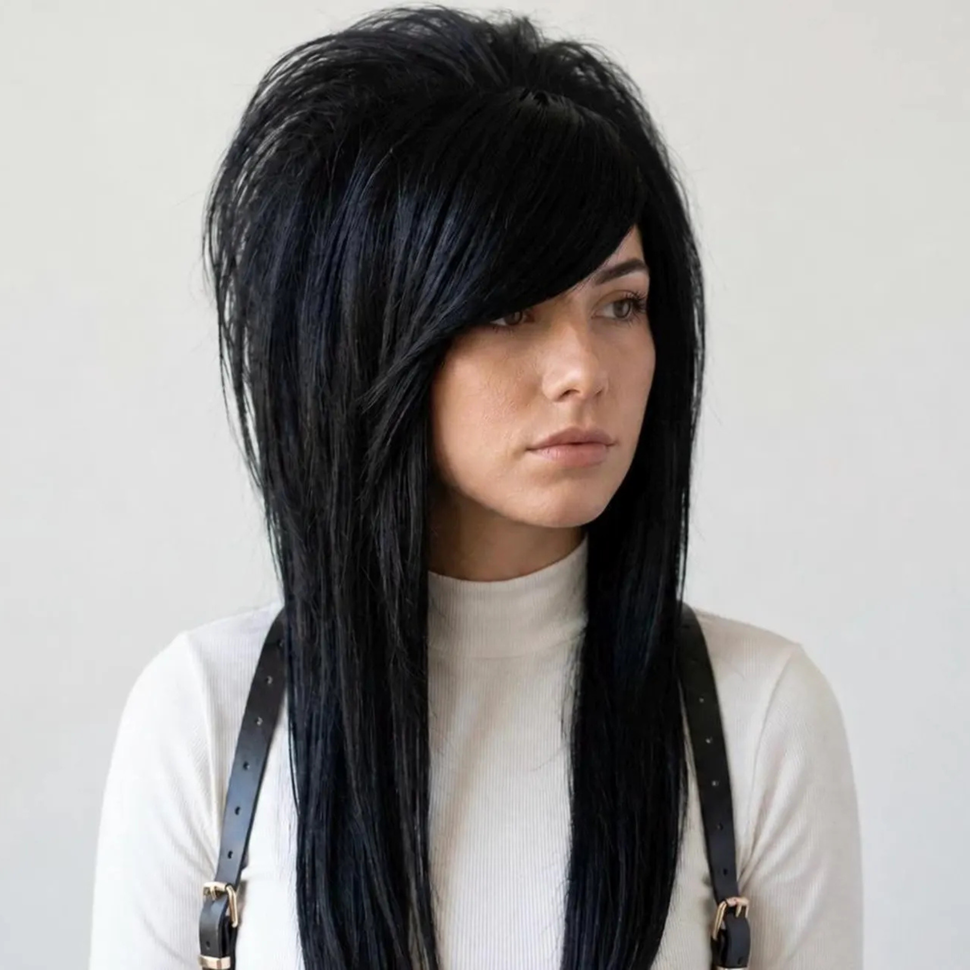 Black emo scene wig with side-swept bangs and long layered synthetic hair, shown on a model from the front.