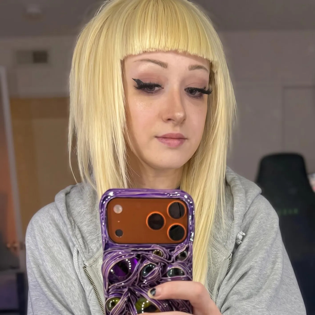 Blonde straight bangs wig worn in a casual mirror selfie, showing the colour and everyday styling.