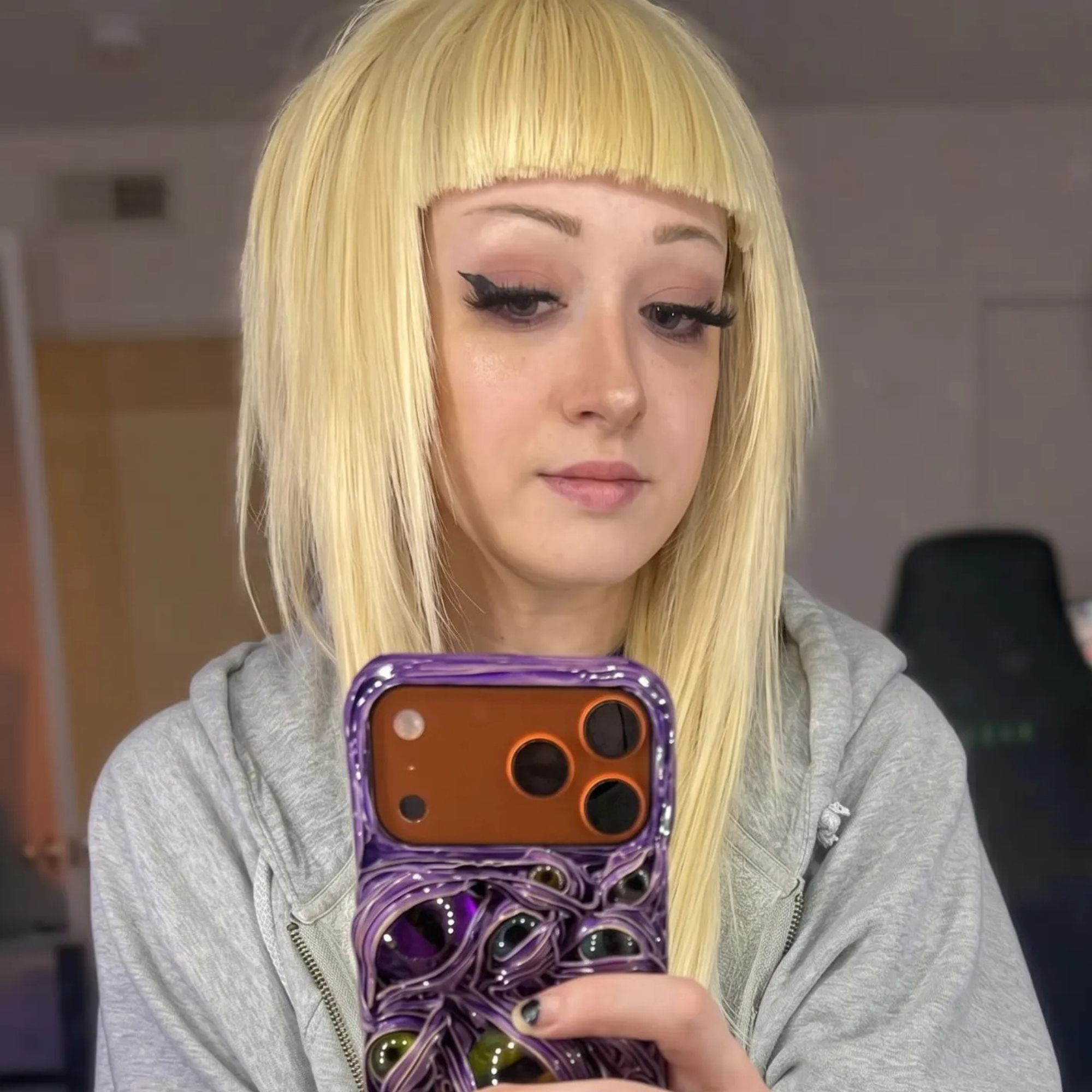 Blonde straight bangs wig worn in a casual mirror selfie, showing the colour and everyday styling.