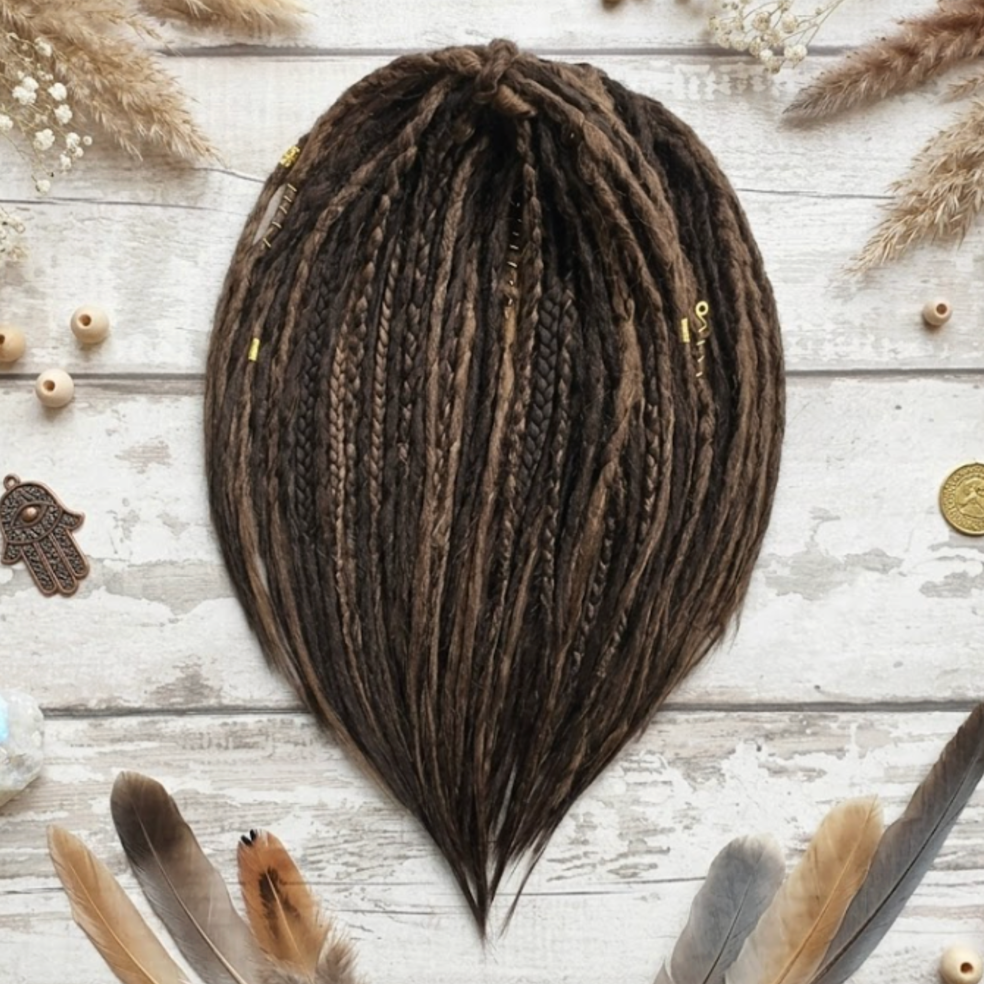 Boho brown dreadlock extensions arranged in a flat lay with mixed brown tones, braid accents and soft loose ends.